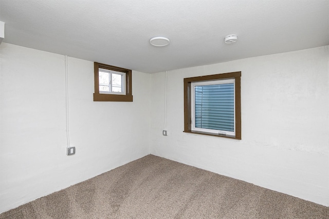 carpeted empty room featuring a textured ceiling