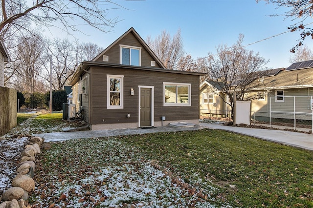 rear view of property featuring a yard and central AC