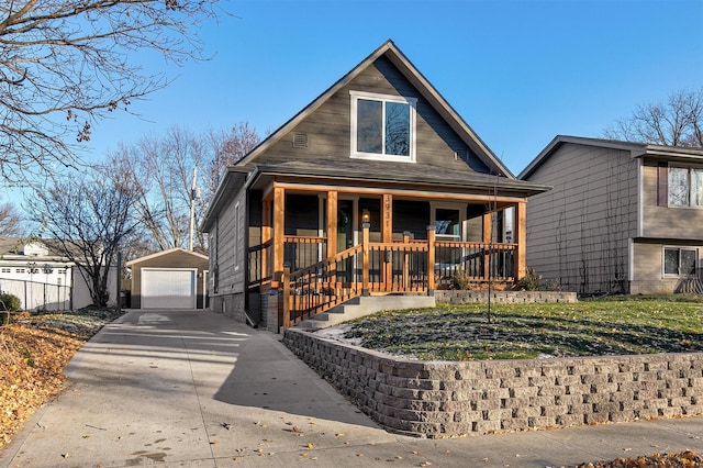 bungalow-style home with a porch, a garage, and an outbuilding