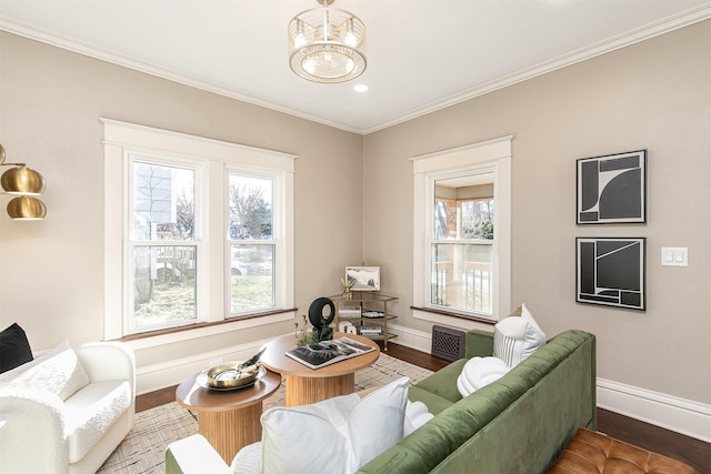 living room with dark hardwood / wood-style floors, crown molding, and a chandelier