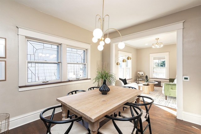 dining area with a notable chandelier, dark hardwood / wood-style flooring, and ornamental molding