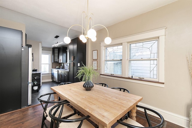 dining room with dark hardwood / wood-style floors, an inviting chandelier, plenty of natural light, and sink