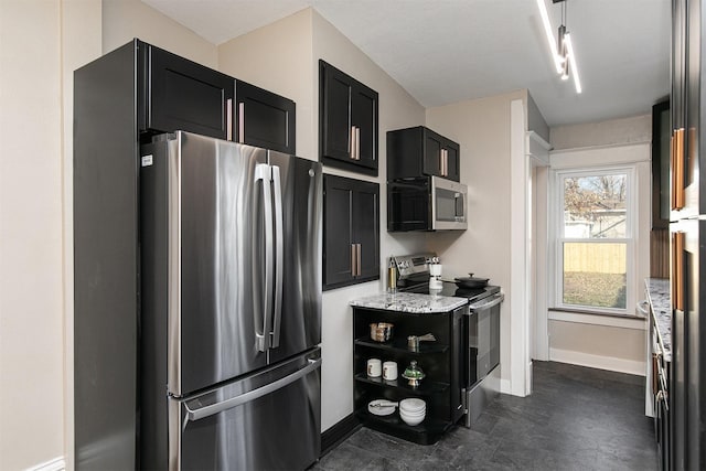 kitchen featuring light stone countertops, appliances with stainless steel finishes, and rail lighting