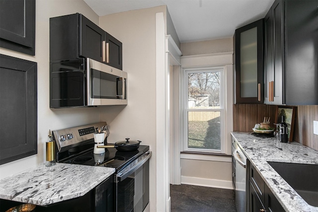 kitchen featuring sink, light stone countertops, and stainless steel appliances