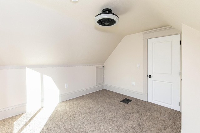 bonus room with light colored carpet and vaulted ceiling