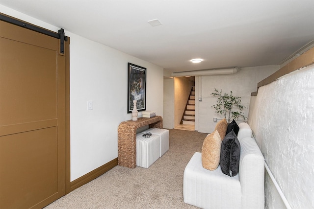 living area featuring a barn door and light colored carpet