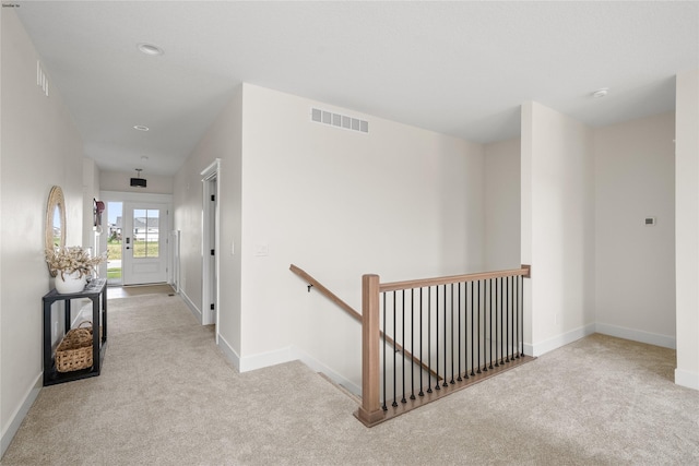 hall featuring light colored carpet