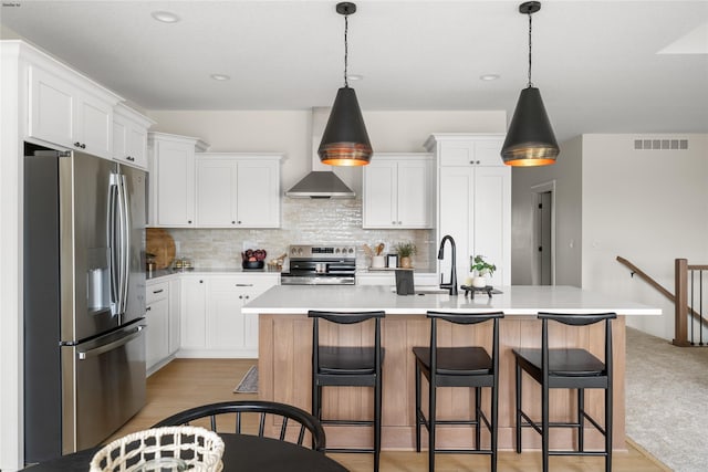 kitchen featuring white cabinetry, stainless steel appliances, and a kitchen island with sink