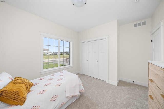 bedroom with light carpet and a closet