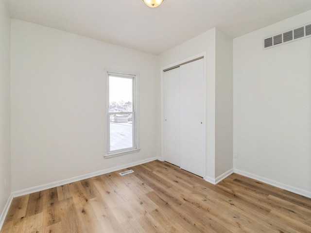 unfurnished bedroom with light hardwood / wood-style floors and a closet