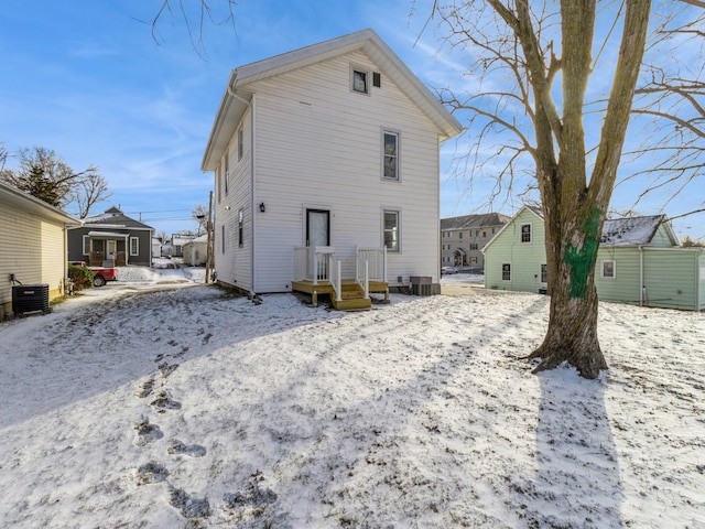 snow covered property with central AC unit