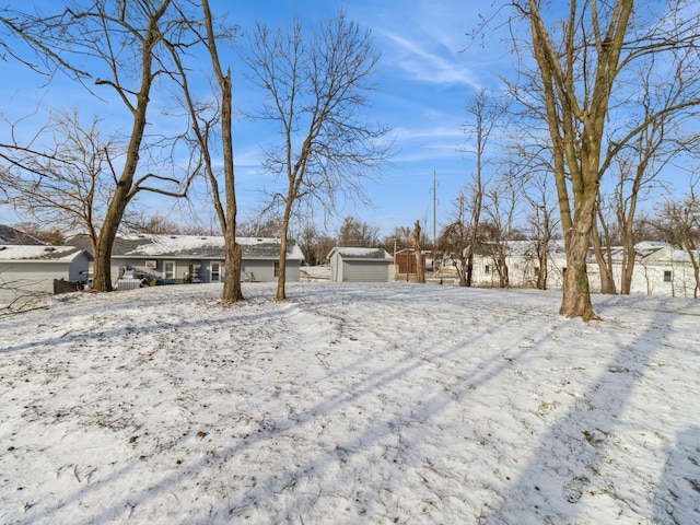 snowy yard featuring a storage unit