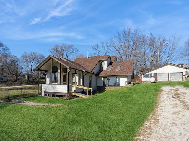 back of house with covered porch, a garage, an outdoor structure, and a lawn