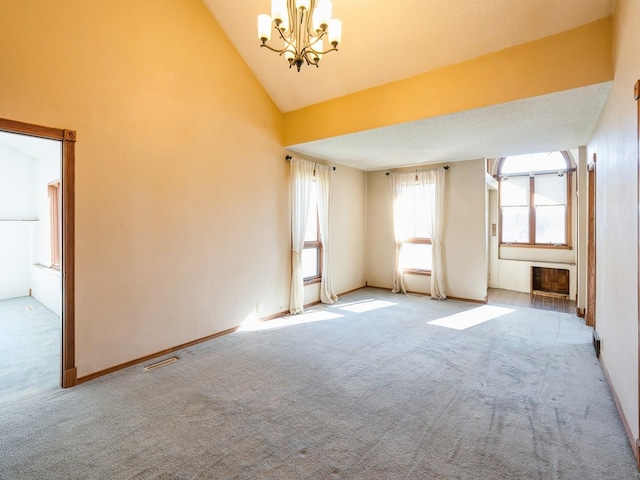 empty room featuring light carpet, high vaulted ceiling, a textured ceiling, and an inviting chandelier