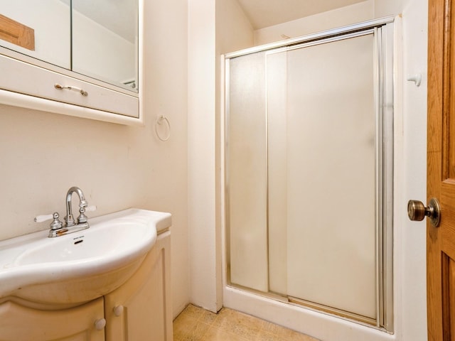 bathroom featuring a shower with door and sink