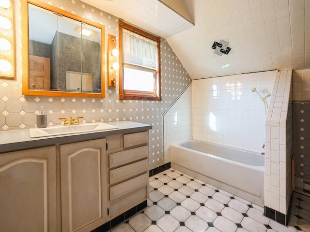 bathroom with vanity, tile walls, and lofted ceiling