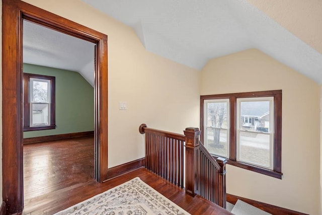 staircase featuring lofted ceiling and hardwood / wood-style flooring