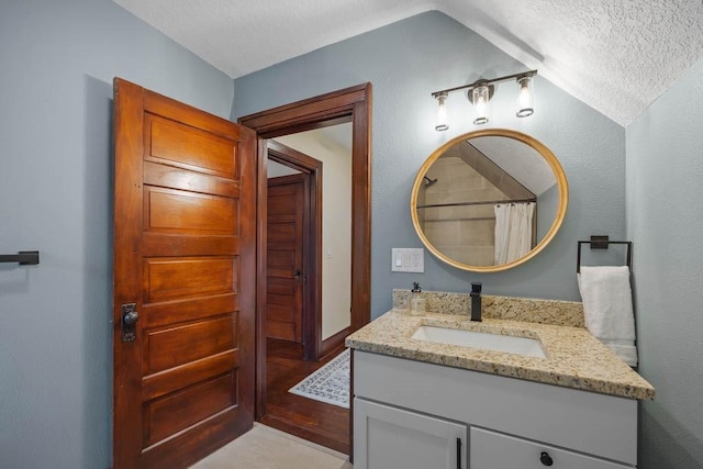 bathroom featuring vanity, a textured ceiling, and a shower with shower curtain