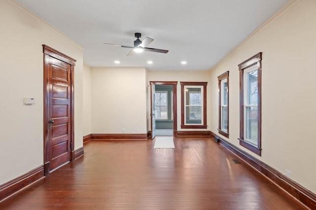 empty room featuring wood-type flooring, crown molding, and ceiling fan