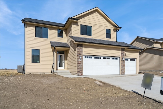 view of front facade featuring stone siding, central AC unit, and concrete driveway