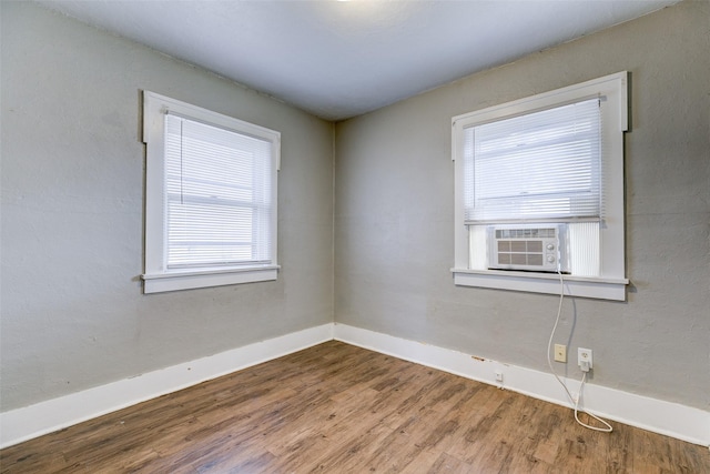 unfurnished room featuring hardwood / wood-style floors and cooling unit