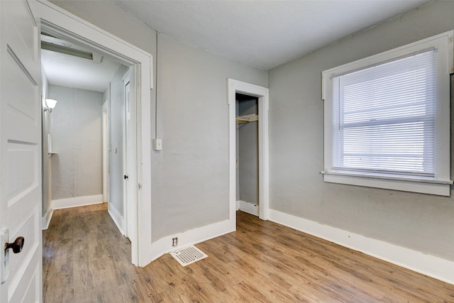 unfurnished bedroom with a closet and light hardwood / wood-style flooring