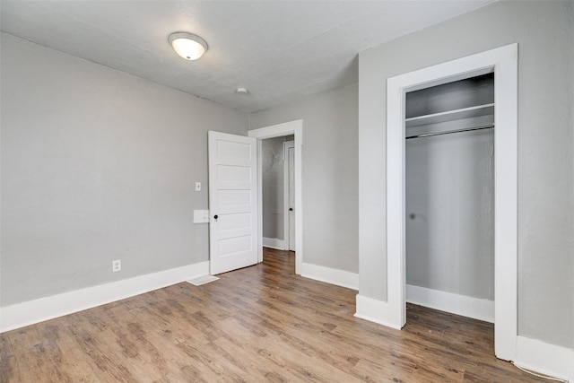 unfurnished bedroom with hardwood / wood-style flooring and a closet