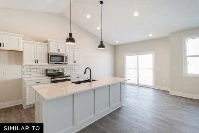 kitchen with stainless steel appliances, a kitchen island with sink, sink, white cabinetry, and hanging light fixtures