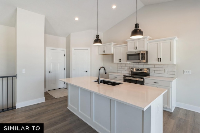 kitchen featuring appliances with stainless steel finishes, sink, decorative light fixtures, white cabinets, and an island with sink