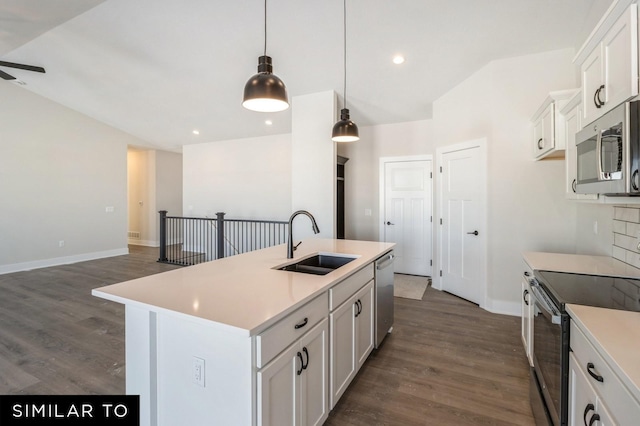 kitchen featuring appliances with stainless steel finishes, sink, white cabinetry, hanging light fixtures, and an island with sink