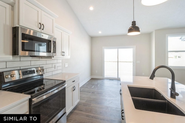 kitchen featuring white cabinetry, sink, tasteful backsplash, dark hardwood / wood-style floors, and appliances with stainless steel finishes