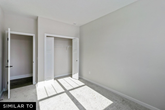 unfurnished bedroom with light carpet and a closet