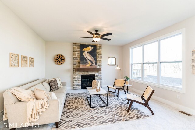 carpeted living room featuring ceiling fan and a fireplace