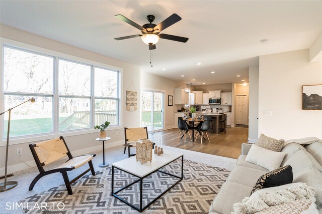 living room featuring ceiling fan and light hardwood / wood-style flooring