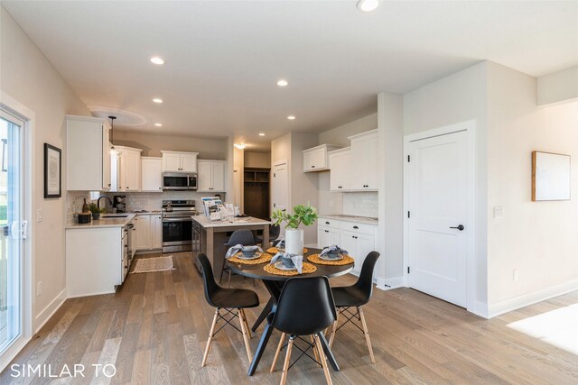 dining room featuring sink and light hardwood / wood-style flooring