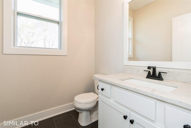 bathroom with tile patterned flooring, vanity, and toilet