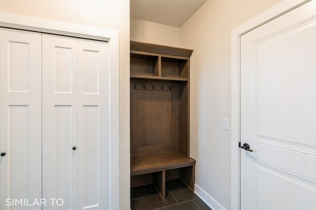 mudroom featuring a textured ceiling and dark tile patterned flooring