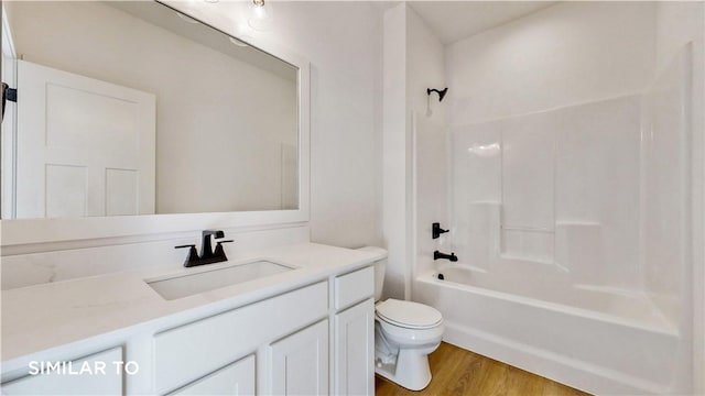 full bathroom featuring hardwood / wood-style floors, vanity, toilet, and shower / washtub combination