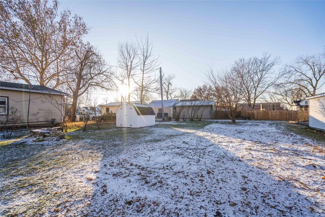 yard layered in snow with a storage unit