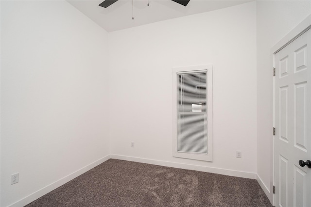 empty room featuring dark carpet and ceiling fan