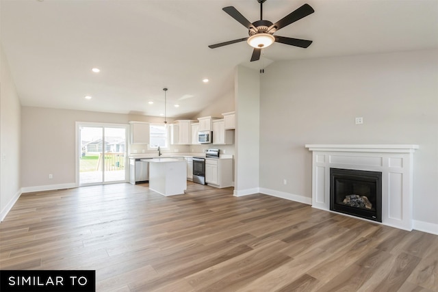 unfurnished living room featuring light wood-type flooring, ceiling fan, and lofted ceiling