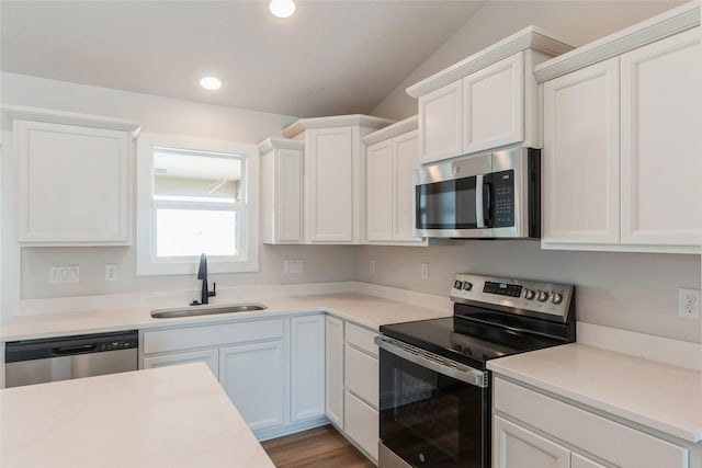 kitchen with white cabinets, stainless steel appliances, a sink, and light countertops