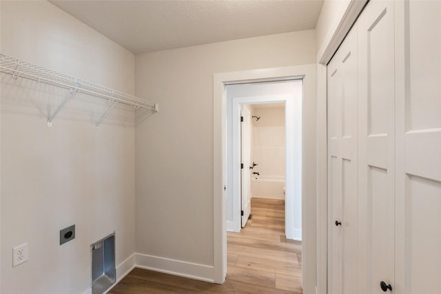 washroom with laundry area, wood finished floors, electric dryer hookup, and baseboards