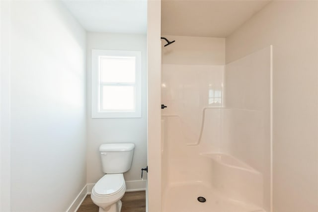 full bath featuring toilet, a shower stall, baseboards, and wood finished floors