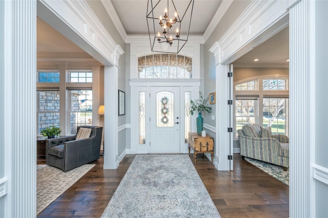 foyer entrance featuring a chandelier, dark hardwood / wood-style floors, and ornamental molding