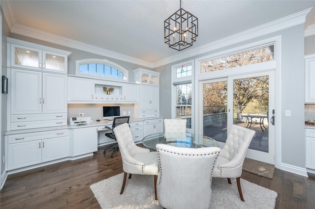 dining space with built in desk, dark hardwood / wood-style floors, and ornamental molding