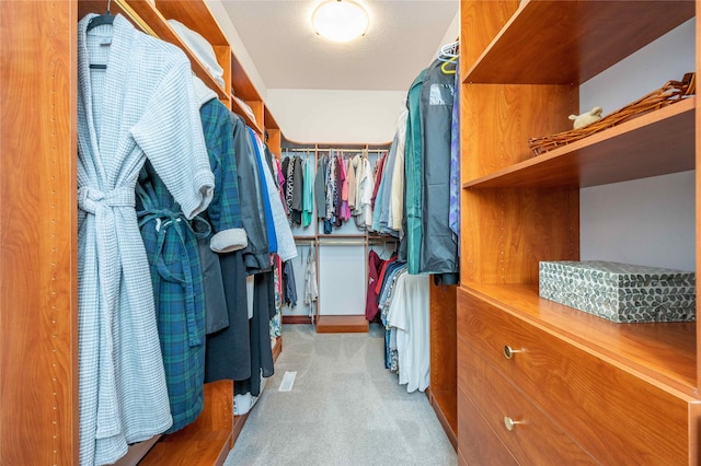 walk in closet featuring light colored carpet