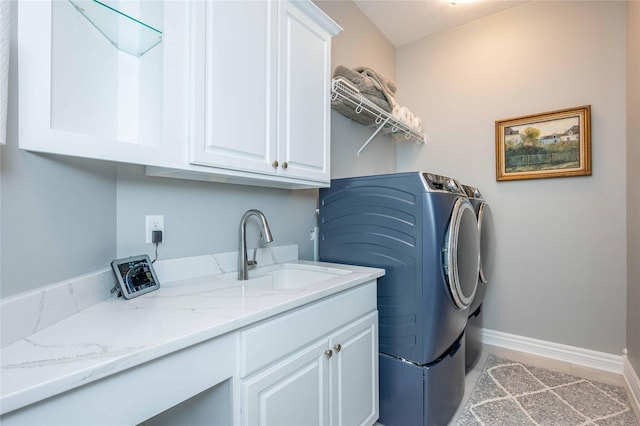 washroom with washing machine and dryer, sink, and cabinets