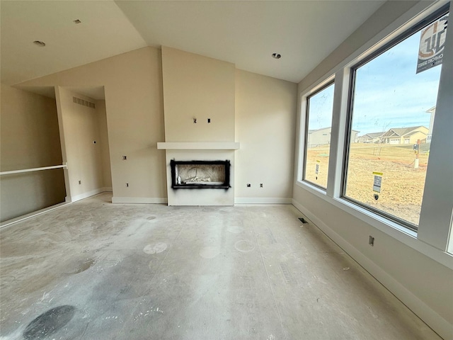 unfurnished living room with lofted ceiling and a healthy amount of sunlight