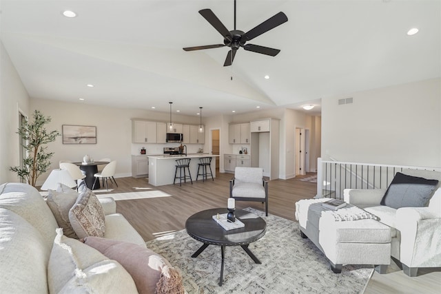 living area featuring recessed lighting, light wood-style floors, visible vents, and baseboards